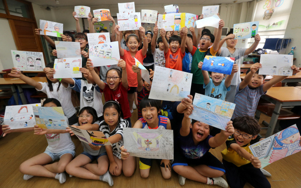 방학을 앞둔 17일 경기도 시흥 정왕초등학교 5학년 6반 아이들이 자신이 방학 때 하고 싶은 일을 그린 그림을 들고 웃고 있다. 강재훈 선임기자 khan@hani.co.kr