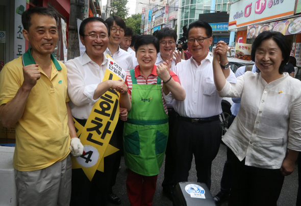 노회찬 정의당 동작을 후보(왼쪽 둘째)가 25일 오전 서울 동작구 사당2동 주민센터에 마련된 투표소에서 사전투표를 한 뒤 박지원 새정치민주연합 의원(오른쪽 둘째), 심상정 정의당 원내대표(맨 오른쪽) 및 주변 상인들과 파이팅을 외치고 있다. 이정우 선임기자 woo@hani.co.kr