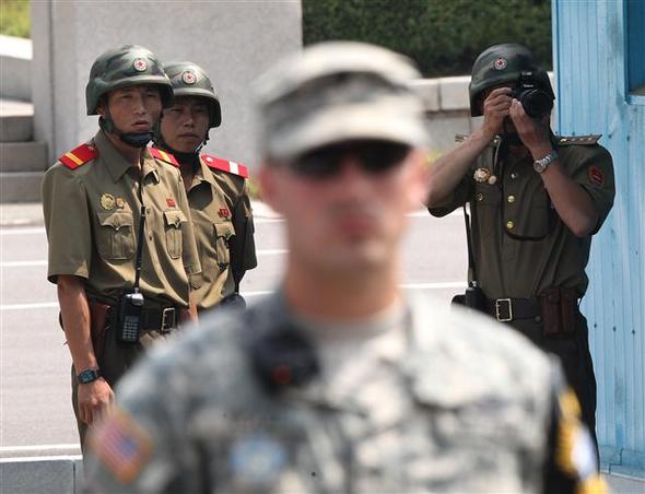 27일 북한군 병사들이 6·25 전쟁 정전협정 61주년을 맞아 판문점 남쪽에서 열리는 기념행사를 지켜보며 사진을 찍고 있다. AP 연합뉴스