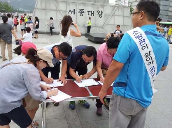 8월9일 서울 광화문 광장에서 시민들이 소방관처우개선을 위한 서명에 참여하고 있다. 광화문 앞 1인시위는 11일 현재 기준 48일째 이어지고 있다. 사진 소방관처우개선국민운동본부 제공