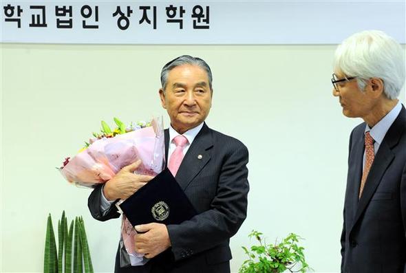 공금 횡령과 부정 입학 등 ‘사학 비리’로 1993년 퇴출된 김문기 전 학교법인 상지학원 이사장이 18일 오전 강원도 원주시 우산동 상지영서대에서 학교 법인 상지학원 이사회로부터 상지대 총장 임명장과 꽃다발을 받고 있다.
원주/연합뉴스
