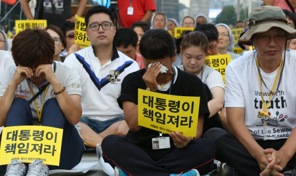 세월호 참사 희생자 유족들이 30일 오후 서울 광화문광장에서 열린 세월호 특별법 제정 촉구 국민대회에서 대통령의 결단을 촉구하는 팻말을 든 채 오열하고 있다. 
 이정우 선임기자 woo@hani.co.kr