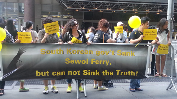 지난달 17일 미국 뉴욕 맨해튼 <뉴욕 타임스> 본사 앞에서 ‘세월호를 잊지 않는 사람들’이 ‘세월호의 진실은 침몰하지 않는다’는 미씨 유에스에이의 광고가 실린 <뉴욕 타임스>를 펴놓고 특별법 제정을 촉구하는 1000만명 서명운동을 하고 있다. <한겨레> 자료사진