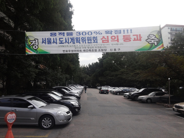 2년8개월째 경비원 등의 임금을 체불하고 있는 서울 서초구 잠원동 ㅇ아파트에 지난달 초 재건축을 위한 절차인 ‘서울시 도시계획위원회 심의’를 통과했다는 내용의 펼침막이 내걸려 있다. 박기용 기자 xeno@hani.co.kr 