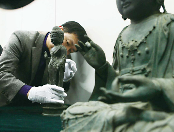 지난해 1월29일 대전지방경찰청 기자실에서 공개된 일본 대마도 도난 불상 2점. 문화재청 관계자가 통일신라시대의 동조여래입상(왼쪽·일본 중요문화재)을 조심스럽게 만지며 살펴보고 있다. 오른쪽 큰 불상은 충남 서산 부석사에 있었다고 전해지는 고려시대의 금동관음보살좌상(나가사키현 지정문화재)이다.
대전/연합뉴스