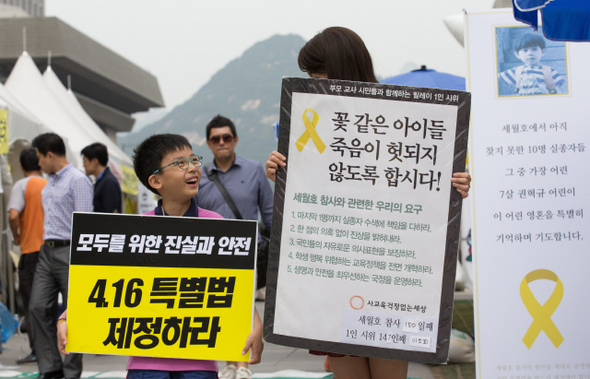 이소희씨가 12일 낮 서울 종로구 광화문광장에서 아들 송상훈군과 함께 세월호 특별법 제정을 촉구하는 내용이 적힌 손팻말을 들고 이야기를 나누고 있다. 이씨는 “내 아이도 결국 미래의 시민이다. 안전한 사회를 만들고 싶다”고 말했다.  
김성광 기자 flysg2@hani.co.kr