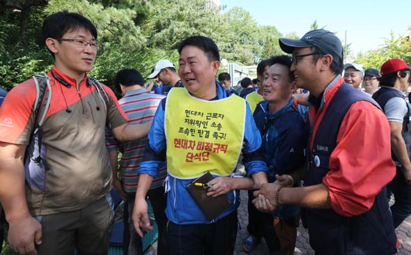 이진환(가운데) 금속노조 현대자동차 비정규직지회 수석부지회장 등 현대차 비정규직 노동자들이 18일 오후 서울 서초동 서울중앙지법 앞에서 현대차와 사내하청업체들을 상대로 낸 근로자 지위 확인 소송에서 승소한 뒤 기뻐하고 있다. 박종식 기자 anaki@hani.co.kr