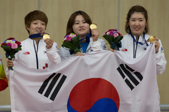 김장미(왼쪽부터), 이정은, 곽정혜가 22일 인천 연수구 옥련국제사격장에서 열린 여자 25ｍ 권총 단체전 시상식에서 금메달을 들어 보이며 활짝 웃고 있다.  인천/김성광 기자 flysg2@hani.co.kr