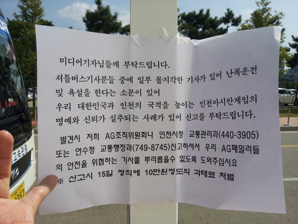 인천아시안게임 조직위원회가 25일 셔틀버스 정류장 앞에 붙인 ‘난폭 운전 버스기사 신고’ 공지문. 그러나 기사들은 “조직위가 버스 운행 현실을 고려하지 않고 정류장 선정 및 운행 시간을 결정했다”고 반발하고 있다. 이번 아시안게임은 대회 운영과 관련해 계속 구설에 오르고 있다. 박현철 기자 fkcool@hani.co.kr