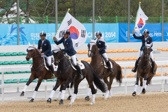 홍원재(왼쪽부터)와 송상욱, 방시레, 전재식이 26일 인천 드림파크승마장에서 열린 승마 종합마술 단체 결승에서 우승한 뒤 태극기를 든 채 경기장을 돌고 있다. 인천/김성광 기자 flysg2@hani.co.kr