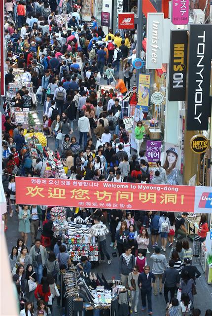 중국 국경절 연휴(1~7일）와 한국의 개천절이 겹친 3일 오후 서울 명동 거리가 시민들과, 요우커（중국인 관광객)들을 비롯한 외국인 관광객들로 붐비고 있다. 현수막에 중국어로 “명동에 오신 것을 환영합니다”라고 적혀 있다.   연합뉴스