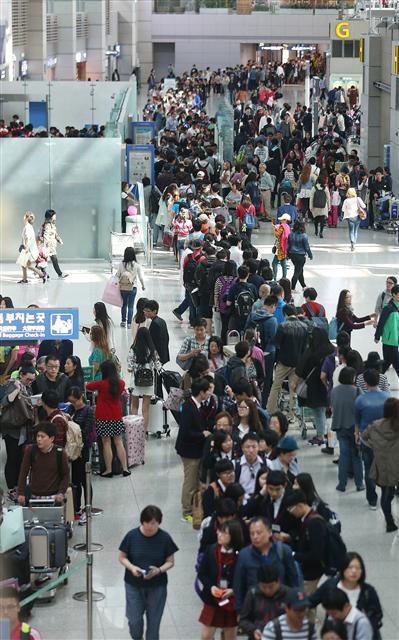 중국과 한국의 연휴, 인천아시안게임 선수단 출국 등이 겹친 5일 오후 인천공항 출국장이 넘치는 인파로 장사진을 이루고 있다.  인천/연합뉴스