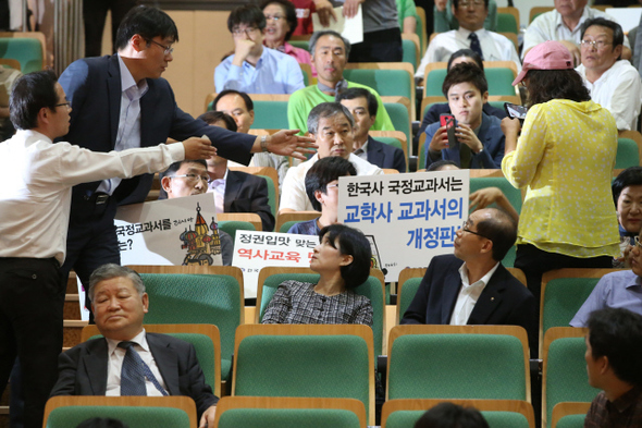 전국교직원노동조합 교사들과 역사정의실천연대 등 시민단체 회원들이 지난 9월25일 오후 서울 서초동 서울교대에서 열린 ‘2015 문·이과 통합형 교육과정 개정 추진에 따른 토론회’ 중 한국사 교과서 국정 전환에 반대하는 손팻말을 들자 행사 진행요원들이 다가와 내려달라고 요청하고 있다. 이정아 기자 leej@hani.co.kr