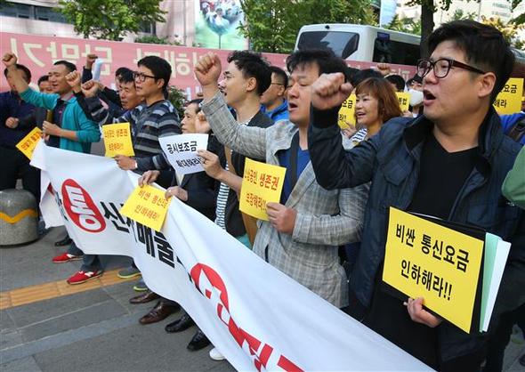 광진테크노마트 상우회 회원들이 13일 오전 서울의 한 이동통신사 본사를 찾아 구호를 외치고 있다. 이들은 법적 지원금 현실화, 현실성 없는 위약금 정책 폐지 등을 요구하고 있다.  연합뉴스
