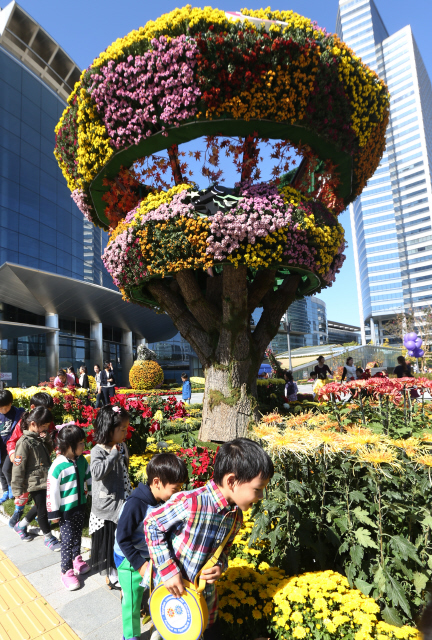 13일 오전 서울 강남구 삼성동 코엑스 앞에서 개막한 ‘2014 무역센터 국화 페스티벌’을 찾은 어린이들이 화려하게 전시된 다양한 국화꽃을 구경하고 있다. 올해로 14회째를 맞은 이 행사에는 100만송이의 국화가 동원돼 한 달간 도심 속에서 가을 향기를 전한다.  신소영 기자 viator@hani.co.kr