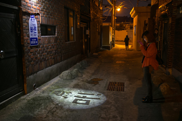 부산 부산진구 양정2동 양지골 골목에 설치된 보안등 ‘마! 라이트’를 주민들이 살펴보고 있다. 부산지방경찰청 제공