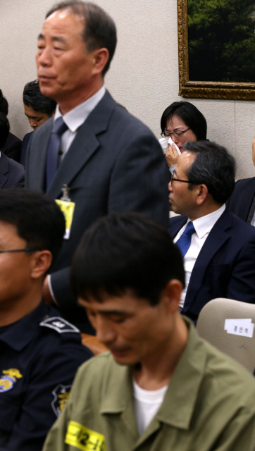 16일 오후 국회에서 열린 농림축산식품해양수산위의 해양수산부·해양경찰청 국정감사에 증인으로 출석한 김경일 해경 123정장(일어선 이)가 선내로 들어가 적극적으로 구조하지 않은 이유를 묻는 의원들의 질의에 답하는 동안 맨뒷줄에 앉은 세월호 희생자 유족들이 흐르는 눈물을 닦고 있다. 맨 앞줄에 앉은 이는 강원식 세월호 일등항해사다. 
이정우 선임기자 woo@hani.co.kr