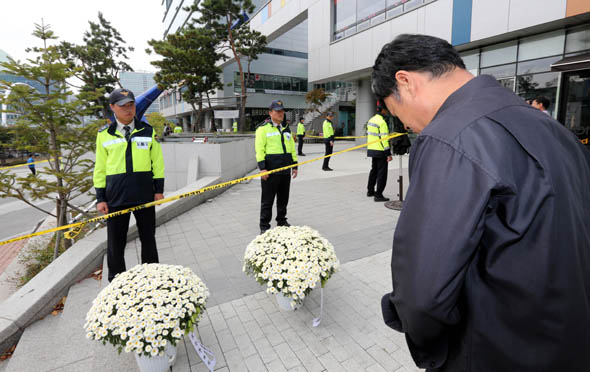 경기도 성남시 ‘판교테크노밸리 축제’ 환풍구 붕괴 참사 현장에 19일 낮 인근 상인이 희생자들의 명복을 비는 문구가 적힌 국화 화분을 가져다 놓고 묵념하고 있다. 성남/강재훈 선임기자 khan@hani.co.kr