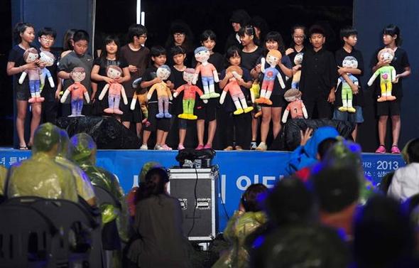 지난해 7월27일 백령도에서 열린 ‘정전 60주년 기념 2013 평화미술프로젝트’ 행사에서 섬 어린이들이 ‘평화’를 주제로 만든 인형극을 마친 뒤 인사하고 있다.  문화체육관광부 제공