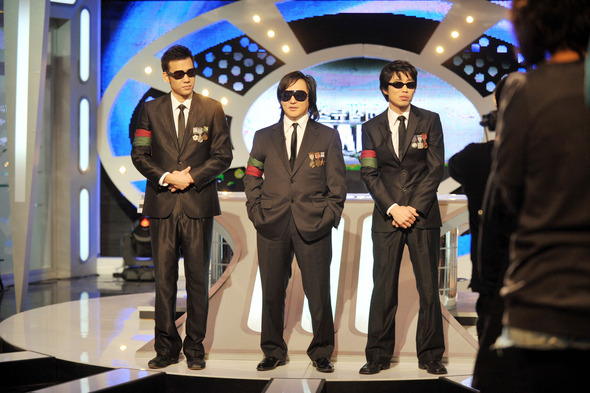 2008년 서울 상암동 DMC 스튜디오에서 진행된 tvN 이색뉴스쇼 ‘스매쉬(SMASH)’ 녹화현장의 신해철. 검은 색 양복과 검은 색 선글라스, 완장을 찬 세 MC는 바로 가수 김진표, 신해철, 그리고 팝칼럼니스트 김태훈(왼쪽부터)