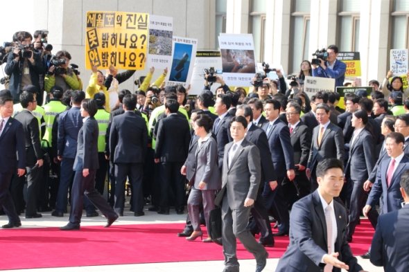 박근혜 대통령이 29일 시정연설과 여야 지도부와의 회담을 마친 뒤 김무성 대표 등 새누리당 지도부와 함께 국회 본청을 나설 때 세월호 유가족들이 피켓 시위를 벌이고 있다. 2014.10.29 / 연합뉴스
