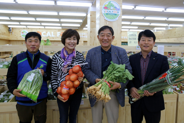 지난 23일 경기도 고양시 덕양구 벽제농협 로컬푸드 직매장에서 이승엽(왼쪽 셋째) 조합장과 직원들이 친환경 농산물을 들고 활짝 웃고 있다.