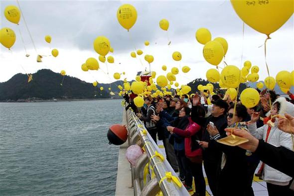 <b>“종이배 타고 돌아오렴”</b> 세월호 참사 발생 200일째인 1일 오후 전남 진도군 임회면 팽목항에서 열린 ‘세월호 참사 200일 팽목항 문화제’에 참가한 시민들이 남은 실종자들의 귀환을 바라며 종이배를 매단 노란 리본을 바다를 향해 날리고 있다. 진도/연합뉴스
