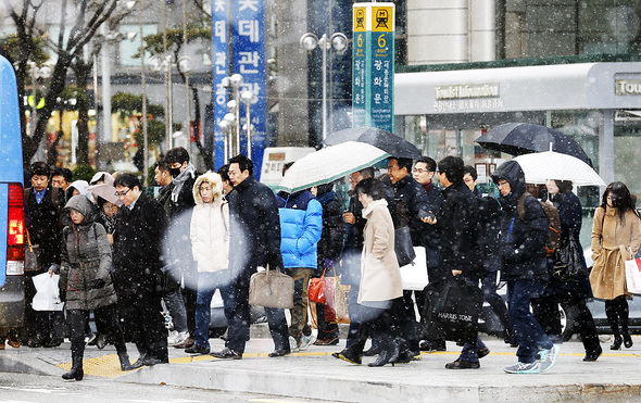 1일 오전 서울 종로구 세종로 네거리에 첫눈이 내리는 가운데 시민들이 출근 발걸음을 서두르고 있다. 이종근 기자 root2@hani.co.kr