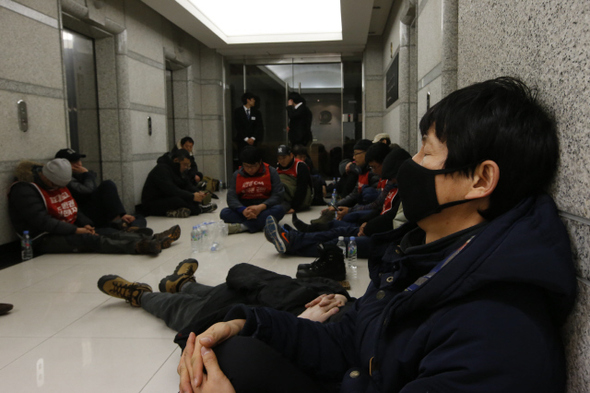 계약 만료를 이유로 109명을 해고한 씨앤앰에 맞서 156일째 거리농성을 하고 있는 희망연대노동조합 씨앤앰 지부와 케이블방송 비정규직 지부 조합원들이 10일 오전 서울시 중구 소공동 맥쿼리 한국지사 사무실 앞에서 해고자 원직 복직 문제 등과 관련한 면담을 요구하다 제지당하자 복도에 앉아 있다. 맥쿼리는 MBK파트너스와 함께 씨앤앰의 대주주다.  
이정아 기자 leej@hani.co.kr