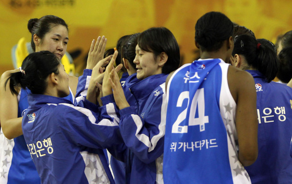 우리은행 선수들이 11일 국민은행을 67-63으로 꺾고 개막 12연승을 달성한 뒤 하이파이브를 하고 있다. 청주/연합뉴스