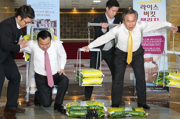 이완구 새누리당 원내대표(왼쪽)와 우윤근 새정치민주연합 원내대표가 16일 오전 국회의사당 중앙홀에서 함께 ‘라이스 버킷 챌린지’에 참가해 쌀포대를 지게로 지고 일어서고 있다. 이정우 선임기자 woo@hani.co.kr