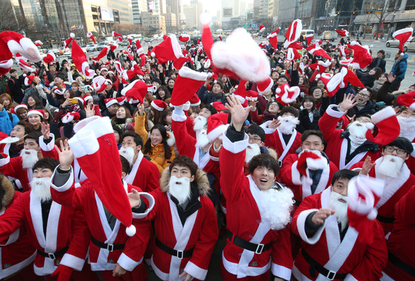 24일 오후 서울 광화문광장에서 열린 ‘2014 몰래 산타 사랑의 대작전’ 출정식에서 참가자들이 어린이들에게 선물을 전달하러 가기 전에 산타 모자를 하늘 높이 던지고 있다. 김태형 기자 xogud555@hani.co.kr