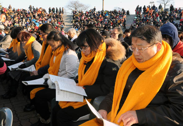 노란 목도리를 두른 세월호 참사 유가족들이 25일 오후 경기도 안산시 단원구 초지동 세월호합동분향소 야외무대에서 열린 ‘세월호 유가족과 함께하는 성탄절 연합예배’에서 찬송가를 부르고 있다. 안산/강재훈 선임기자 khan@hani.co.kr