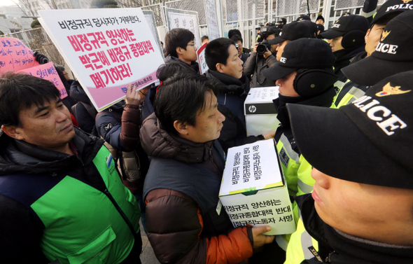 비정규직 노동자들이 29일 오전 서울 세종로 정부서울청사 앞에서 ‘비정규직법 관련 비정규직 당사자 긴급 기자회견’을 연 뒤 비정규직종합대책 폐지 서명서를 들고 청사로 들어가려다 경찰에 제지당하고 있다. 김경호 선임기자 jijae@hani.co.kr