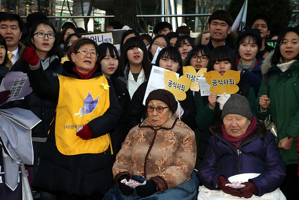 제1159차 일본군 위안부 문제 해결을 위한 정기 수요시위가 열린 31일 낮 서울 종로구 중학동 주한일본대사관 앞에서 길원옥(오른쪽부터) 김복동 할머니가 올해 별세한 위안부 피해자 황금자, 배춘희 할머니의 약력을 들으며 가슴아픈 표정으로 고인의 삶을 추모하고 있다. 이정아 기자 leej@hani.co.kr