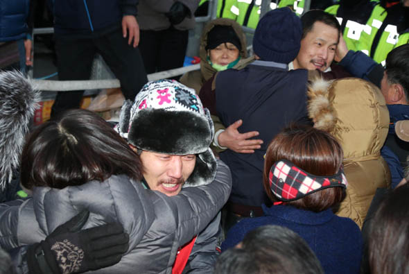 서울 도심 한복판 전광판 위에서 50일간 고공농성을 벌여온 씨앤앰 해고노동자 임정균(왼쪽)씨와 강성덕씨가 31일 오후 중구 태평로 한국언론회관 앞 전광판에서 농성을 풀고 내려와 가족의 품에 안겨 눈물을 흘리고 있다. 이정우 선임기자 woo@hani.co.kr