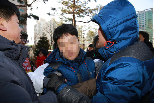 쌍용자동차 해고노동자들의 오체투지 현장에서 무단으로 현장채증을 하던 구로경찰서 정보과 최아무개씨가 7일 오전 오체투지 참가자들의 거센 항의를 받고 있다. 최아무개씨는 참가자들이 신분확인 요청을 하자 <오마이뉴스> 기자라고 사칭을 했다. 류우종 <한겨레21> 기자 wjryu@hani.co.kr
