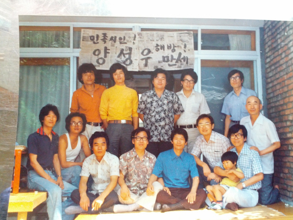 1977년 6월 유신체제를 비판한 장시 ‘노예수첩’이 일본 잡지에 실린 뒤 ‘국가모독죄’란 혐의로 구속된 양성우 시인은 79년 7월17일 제헌절 특사로 풀려났다. 그길로 고은 시인의 서울 화곡동 자택에서 자유실천문인협의회 회원들과 친구 등과 만나 밤새 석방 환영의 회포를 나눈 뒤 이튿날 아침 기념사진을 찍었다. 신문지를 붙여 ‘민족시인! 양성우 해방 만세!’라고 내건 펼침막은 고은 시인의 솜씨다. 뒷줄 왼쪽부터 시계 방향으로 장만철(장선우 감독) 성종대 양관수 이명준 이시영 고은 박태순 백낙청 양성우 염무웅 임채정 송기원 이진행. 사진 작가회의 제공
