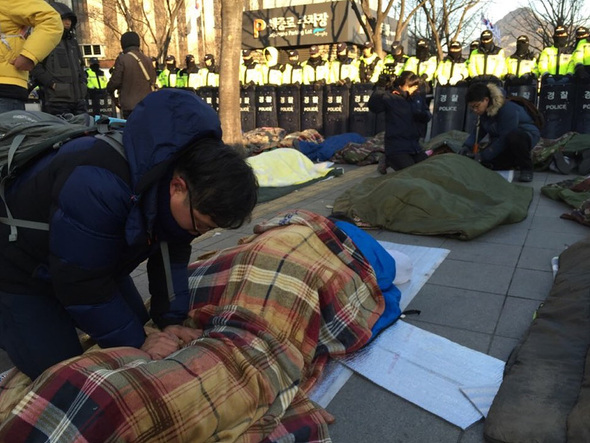 비정규직 철폐와 해고자 복직을 요구하며 오체투지로 청와대로 향하던 쌍용자동차 해고노동자들과 비정규직 노동자들이 12일 오전 서울 종로구 세종로 정부서울청사 앞에서 108배를 마친 뒤 휴식을 취하고 있다. 김성광 기자 flysg2@hani.co.kr