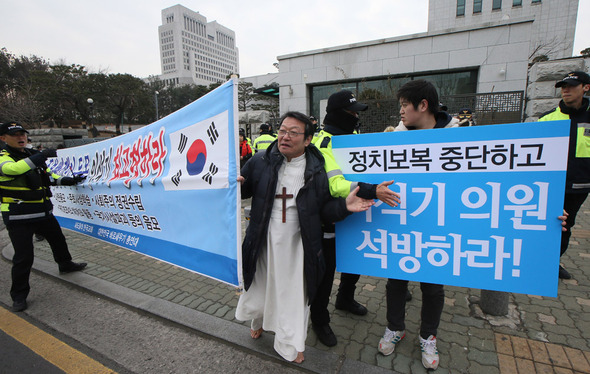 이른바 ‘이석기 내란음모 사건’에 대한 대법원 전원합의체의 선고일인 22일 오후 서울 서초동 대법원 앞에서 진보와 보수단체 회원들이 각각 공판과 관련된 선전활동을 하다 실랑이를 하고 있다.  연합뉴스