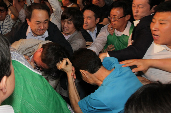 지난 2012년 조준호 공동대표(왼쪽)가  경기도 고양시 일산킨텍스 그랜드볼룸에서 열린 진보통합당 중앙위원회에서 ‘강령 개정안 심의·의결의 건’이 처리되는 순간 단상으로 뛰어든 한 당원에게 머리채를 붙잡힌 채 공격당하고 있다. 강창광 기자 chang@hani.co.kr