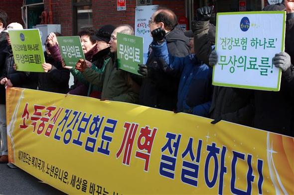 내가 만드는 복지국가, 노년유니온 등 시민사회단체 관계자들이 30일 오전 서울 청운효자동 주민센터 앞에서 정부의 건강보험료 부과체계 개편 중단을 규탄하며 재추진을 요구하고 있다.  연합뉴스