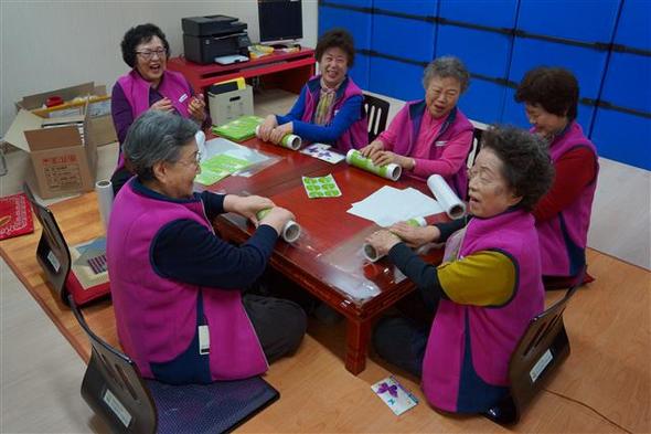 지난달 27일 서울 성북구 길음뉴타운 8단지 제2경로당 공동작업장에서 할머니들이 두루마리 위생봉투를 포장하고 있다. 성북구 제공