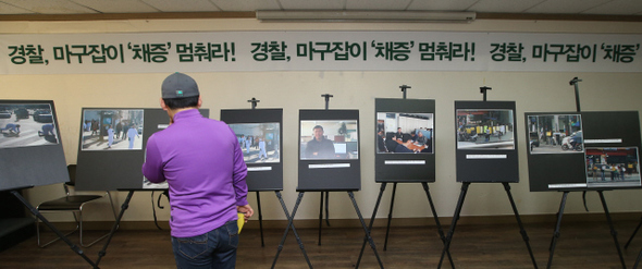 4일 오전 서울 중구 민주노총에서 인권단체연석회의 공권력감시대응팀 주최로 열린 ‘경찰 불법채증 규탄 기자회견’을 마친 참석자들이 경찰이 쌍용차 해고자 복직을 위한 오체투지 행진단을 불법 채증한 사진 등을 구경하고 있다. 신소영 기자 viator@hani.co.kr