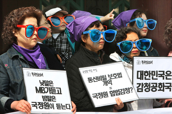 2009년 4월 23일 민주화실천가족운동협의회 회원들이 서울 종로3가 탑골공원 들머리에서 권력기관의 감시를 상징하는 색안경을 낀 채 ‘통신비밀보호법’ 개악 움직임을 비판하고 있다.