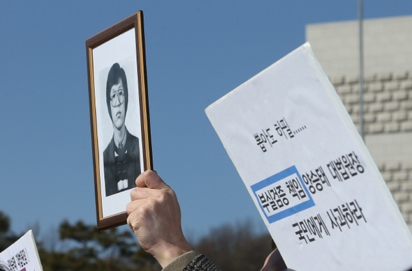 참여연대 등 시민사회단체 회원들이 2일 오전 서울 서초동 대법원 앞에서 박상옥 대법관 후보자 제청 철회를 촉구하는 손팻말과 1987년 당시 고문으로 숨진 서울대생 박종철씨의 사진을 들어 보이고 있다. 이들은 기자회견을 마친 뒤 대법원에 제청철회 요구서를 제출했다.  신소영 기자 viator@hani.co.kr