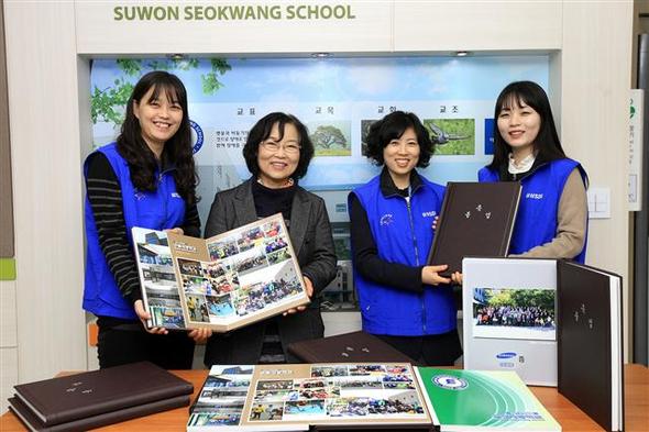 삼성에스디아이 임직원들이 13일 경기도 수원시 이목동의 수원서광학교 한정애 교장에게 졸업앨범을 전달하고 있다. 삼성에스디아이 제공