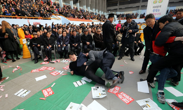강원도 원주 상지대 총학생회 간부들이 13일 오후 이 학교 체육관에서 열린 졸업식에서 지난해 8월 학교로 복귀한 김문기 총장의 사퇴를 촉구하는 시위를 벌이다 학교 관계자들에게 제지당하고 있다.  원주/김경호 선임기자 jijae@hani.co.kr