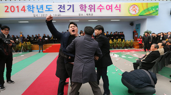 강원도 원주 상지대학교 총학생회 간부들이 13일 오후 학교 체육관에서 열린 학위수여식에서 지난해 8월 학교로 복귀한 김문기 총장의 사퇴를 촉구하는 기습시위를 벌이고 있다. 원주/김경호 선임기자 jijae@hani.co.kr