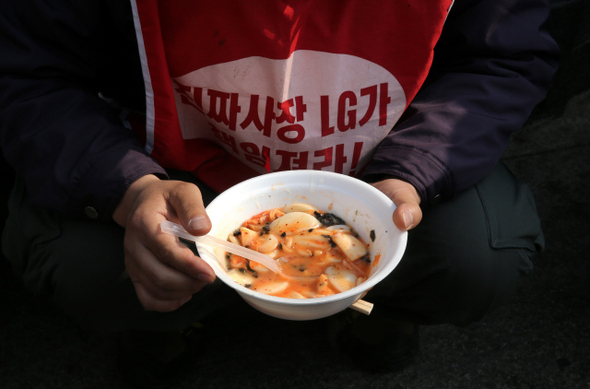 15일 낮 서울 중구 서울중앙우체국 앞에서 열린 ‘LG유플러스·SK브로드밴드 비정규직 노동자와 함께하는 떡국 한마당’ 행사
도중 희명연대노조 조합원들이 끓여서 나눠준 떡국을, 장기 농성 중인 한 노동자가 쪼그려 앉아 먹고 있다.
강재훈 선임기자 khan@hani.co.kr